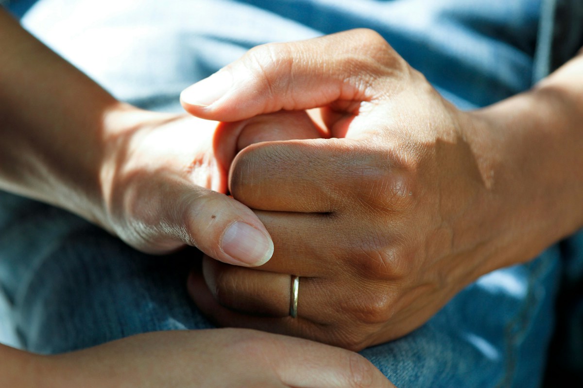 Compassionate hands holding tight with warmth and emotional healing